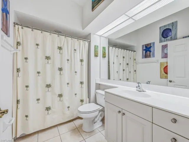 a bathroom with a sink a toilet and a large mirror