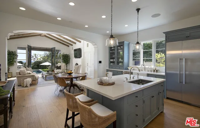 a living room with furniture a fireplace and potted plants