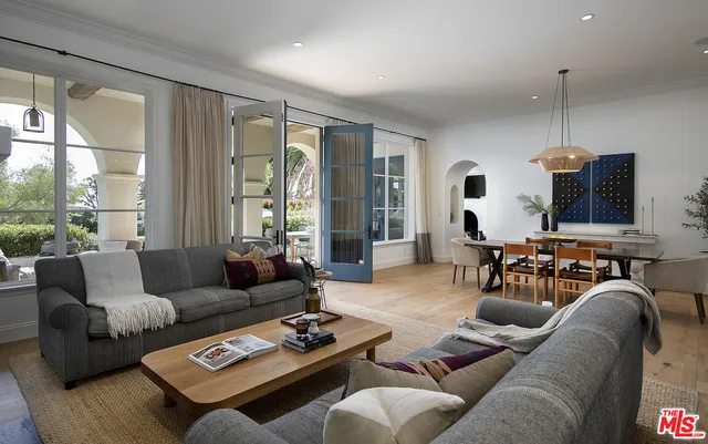 a living room with furniture potted plant and a large window