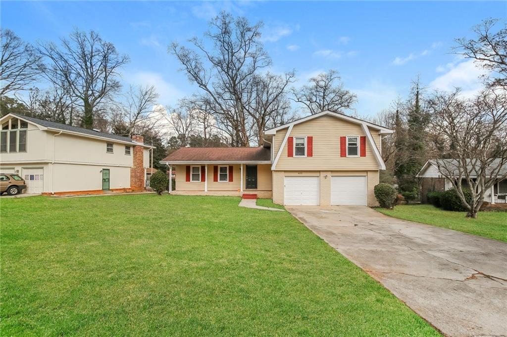 a front view of a house with a garden and trees