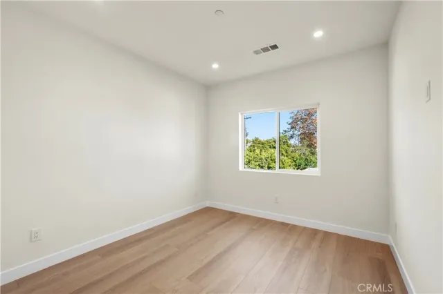 an empty room with a window and painting on the wall