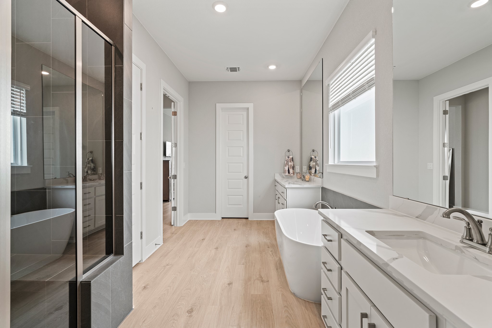 2112 Tobiano Trace Georgetown, TX 78633 - Photo 20 of 40 Full bathroom featuring a soaking tub, two vanities, light wood-style floors, and recessed lighting