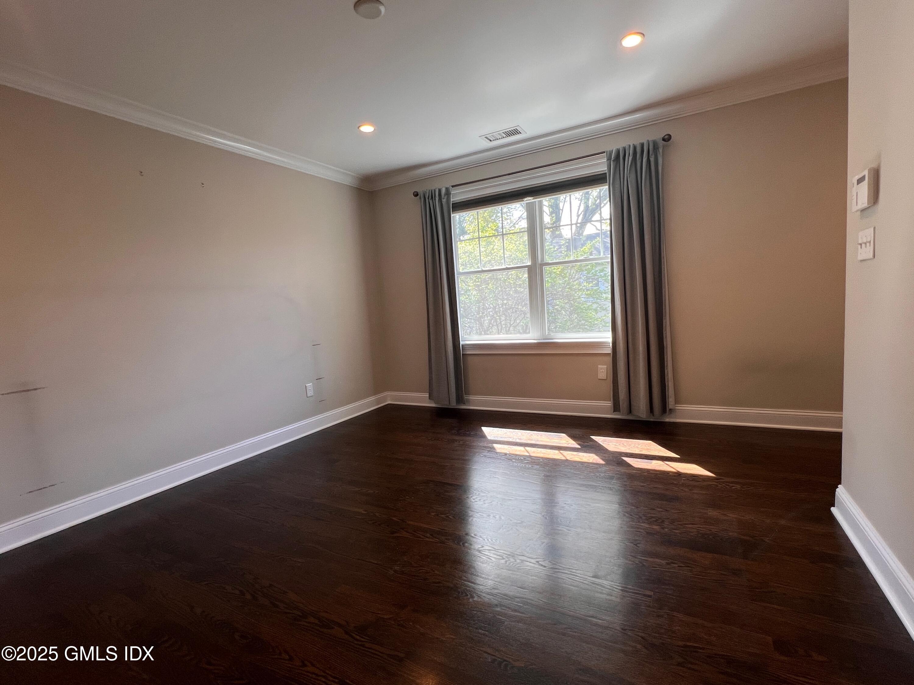 31 Moshier Street, Unit B Greenwich, CT 06831 - Photo 15 of 28 a view of an empty room with wooden floor and a window