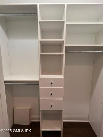 a view of walk in closet with empty racks