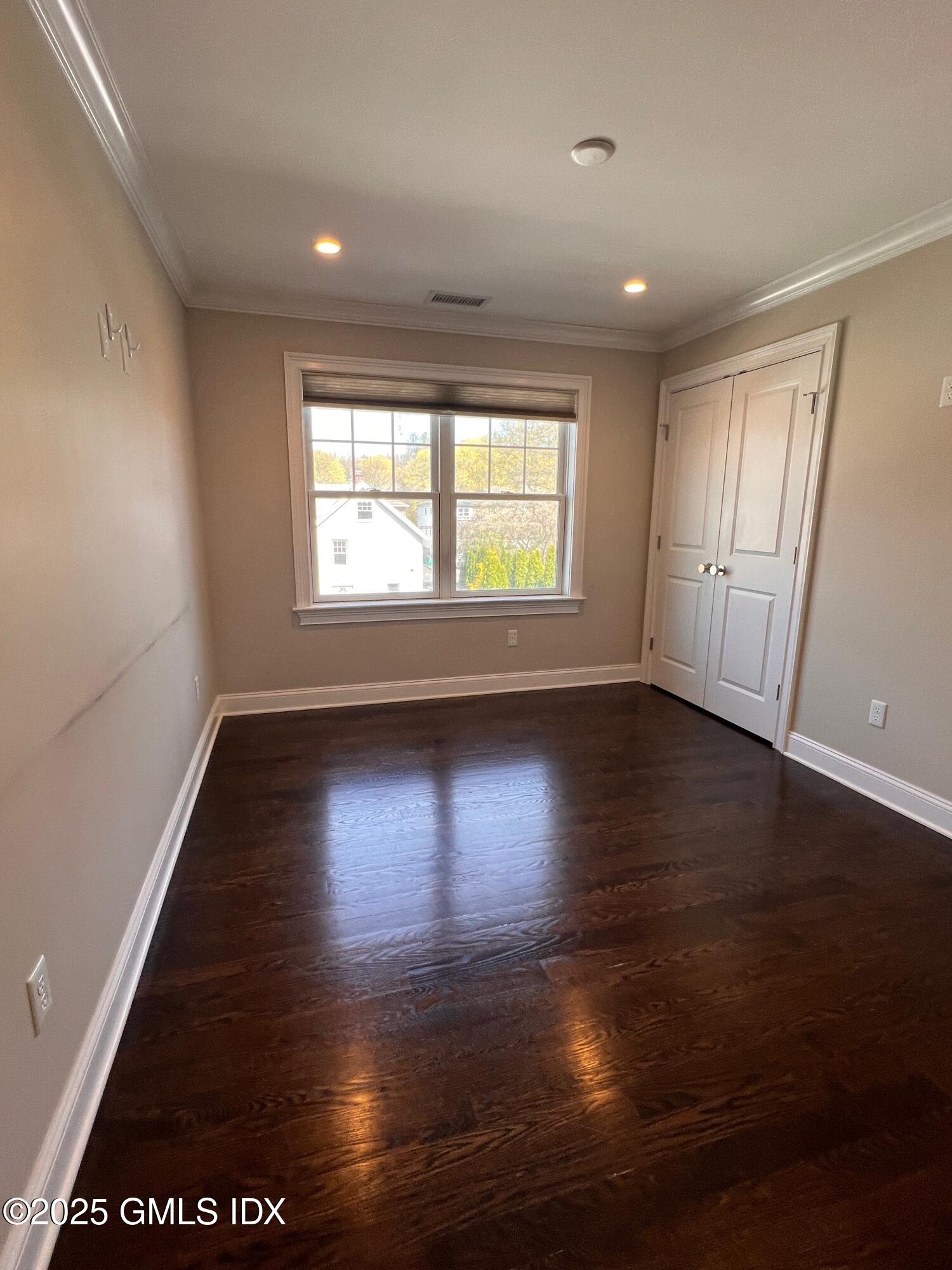 31 Moshier Street, Unit B Greenwich, CT 06831 - Photo 17 of 28 an empty room with wooden floor and windows with curtains