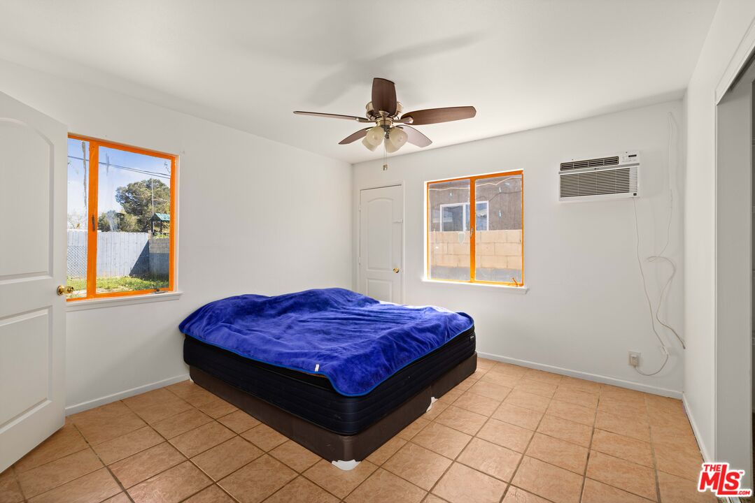 38466 Sumac Avenue Palmdale, CA 93550 - Photo 13 of 18 a spacious bedroom with a bed and a window
