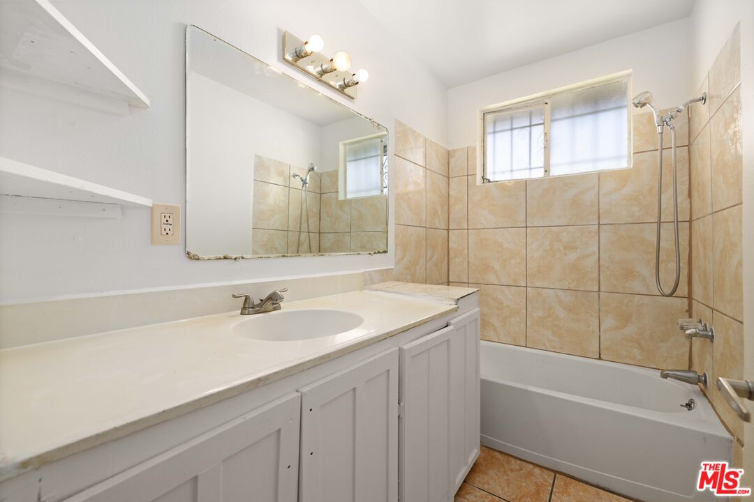 38466 Sumac Avenue Palmdale, CA 93550 - Photo 15 of 18 a bathroom with a sink a bathtub a shower and a mirror