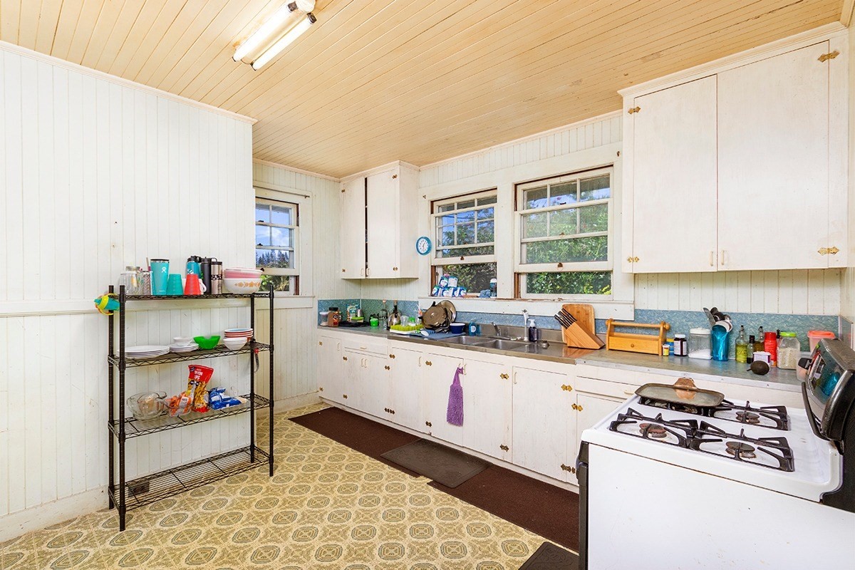 18-1222 Volcano Road Mountain View, HI 96771 - Photo 5 of 29 a kitchen with a stove a sink and cabinets