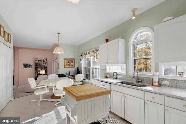 a kitchen with stainless steel appliances a sink a stove and white cabinets