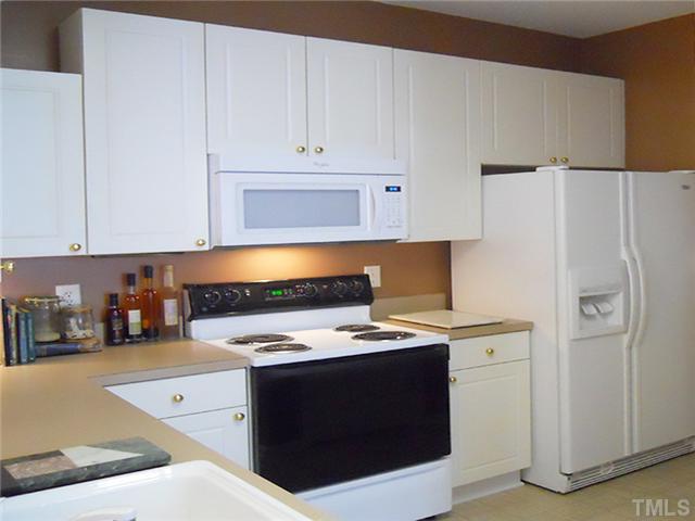 2004 Metacomet Way Raleigh, NC 27604 - Photo 8 of 23 a kitchen with stainless steel appliances a refrigerator a stove a sink and white cabinets