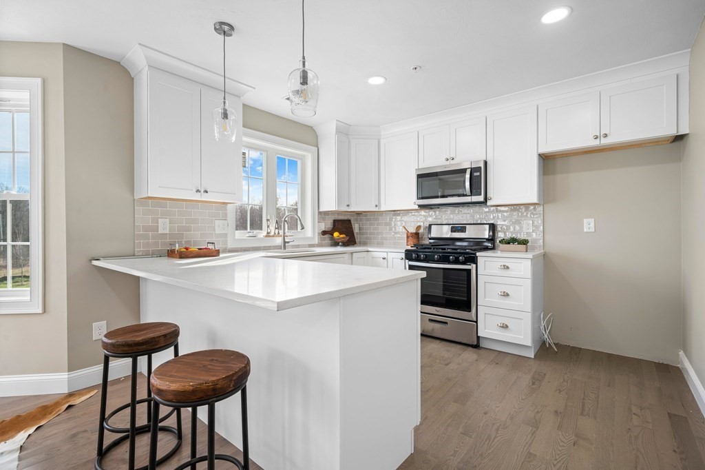 184 Berlin Road Bolton, MA 01740 - Photo 3 of 33 a kitchen with granite countertop white cabinets and stainless steel appliances