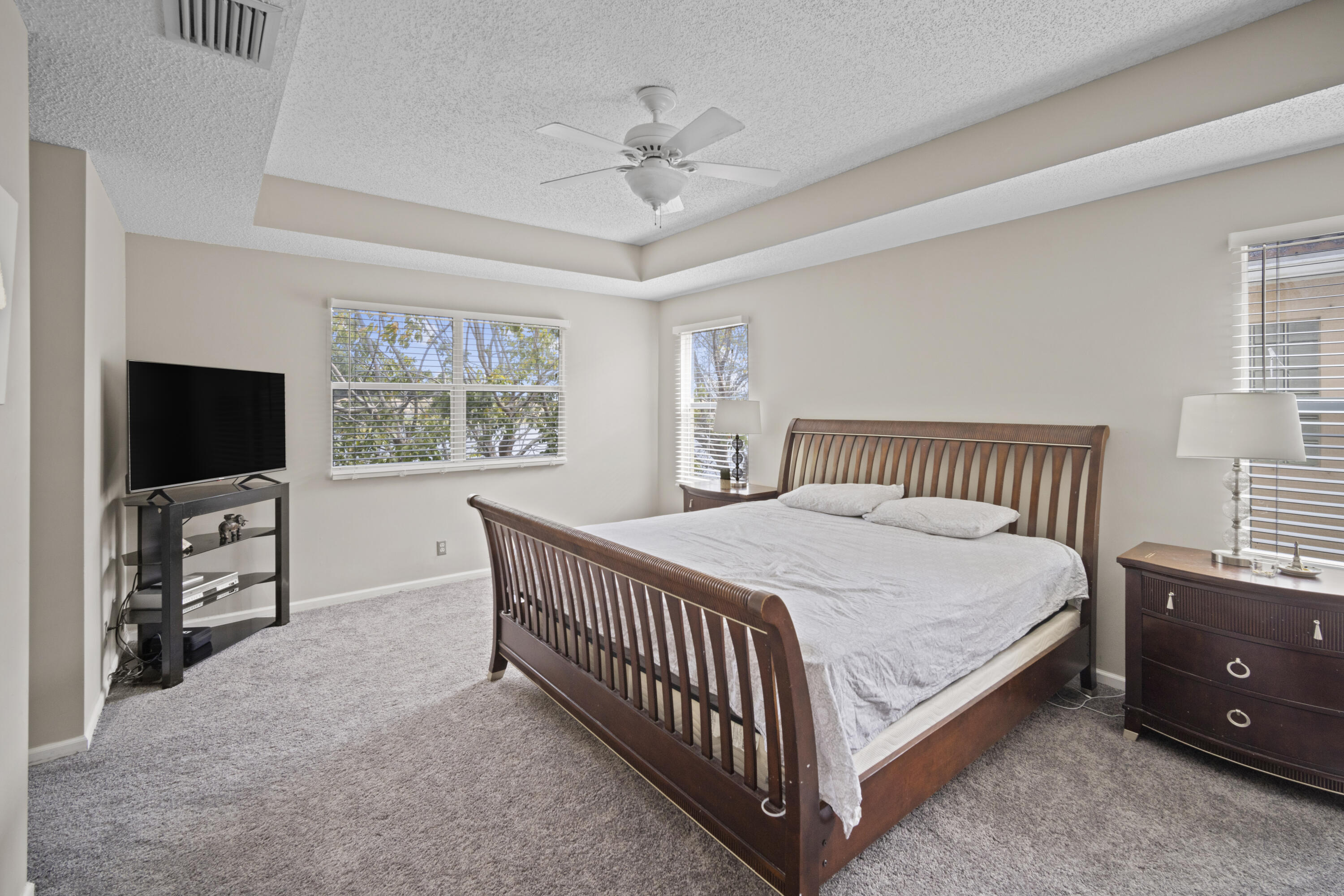 6427 Adriatic Way Greenacres, FL 33413 - Photo 23 of 33 a bedroom with a bed and a flat screen tv