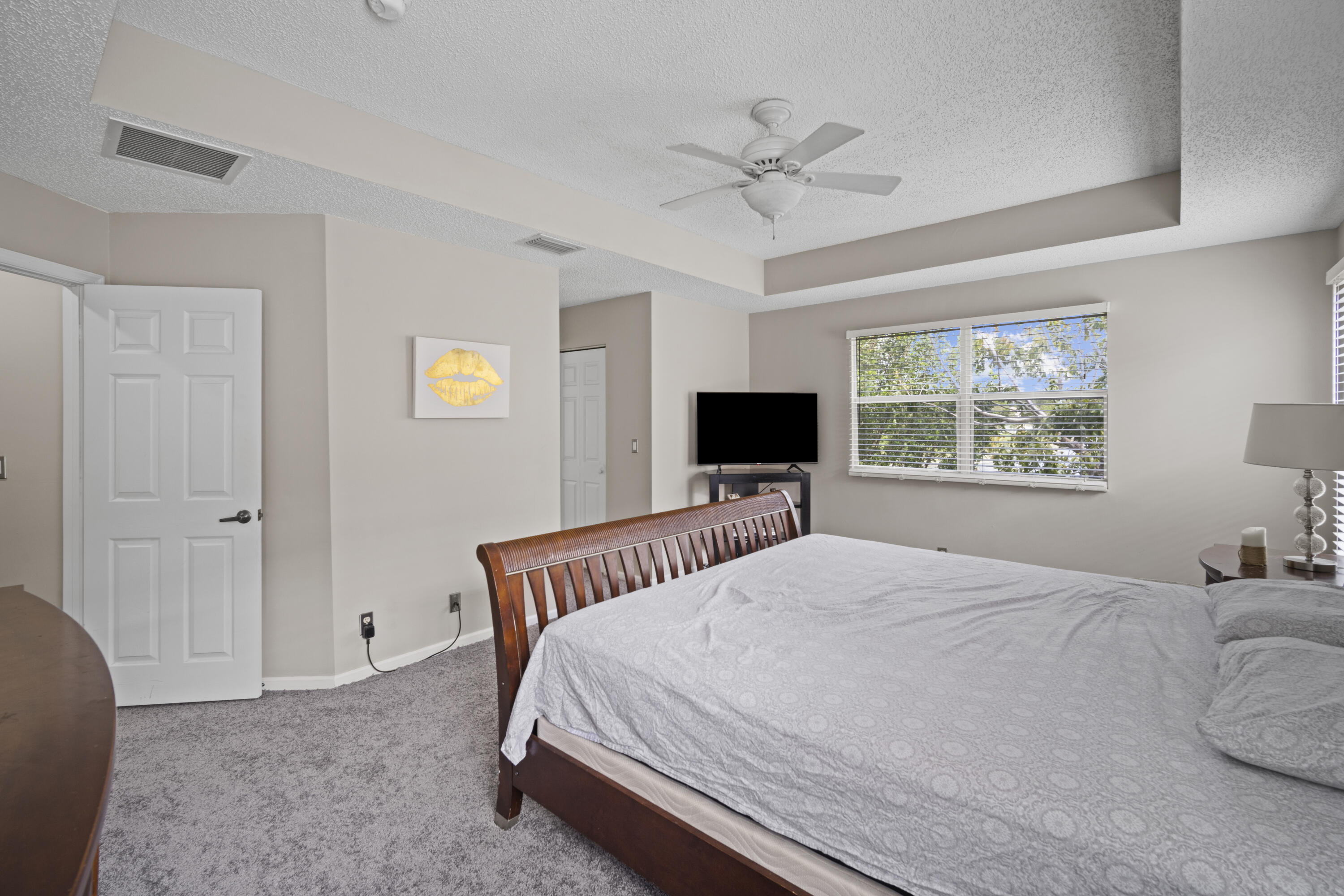 6427 Adriatic Way Greenacres, FL 33413 - Photo 24 of 33 a bedroom with a bed and a flat screen tv