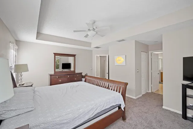 a bedroom with a large bed and a chandelier