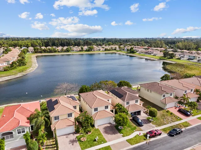 an aerial view of residential houses with outdoor space and ocean view
