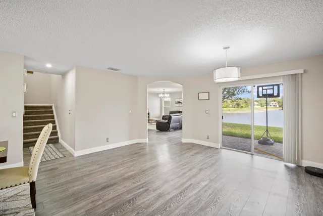 an empty room with wooden floor and natural light