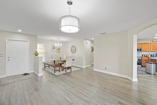 a view of a dining room with furniture wooden floor and chandelier