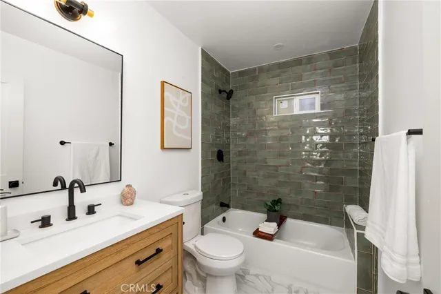 a bathroom with a sink a toilet a mirror and shower