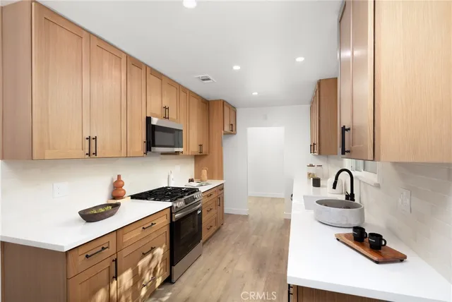 a kitchen with stainless steel appliances granite countertop a sink stove and cabinets