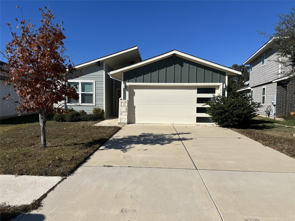 a front view of a house with a yard and trees