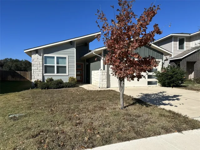 a view of a house with a tree in the yard