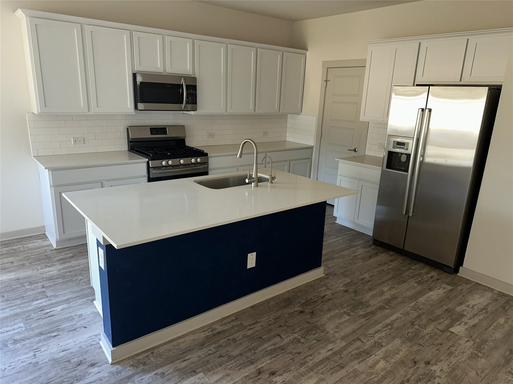 241 Deserti Road Leander, TX 78641 - Photo 6 of 24 a kitchen with a refrigerator sink and cabinets