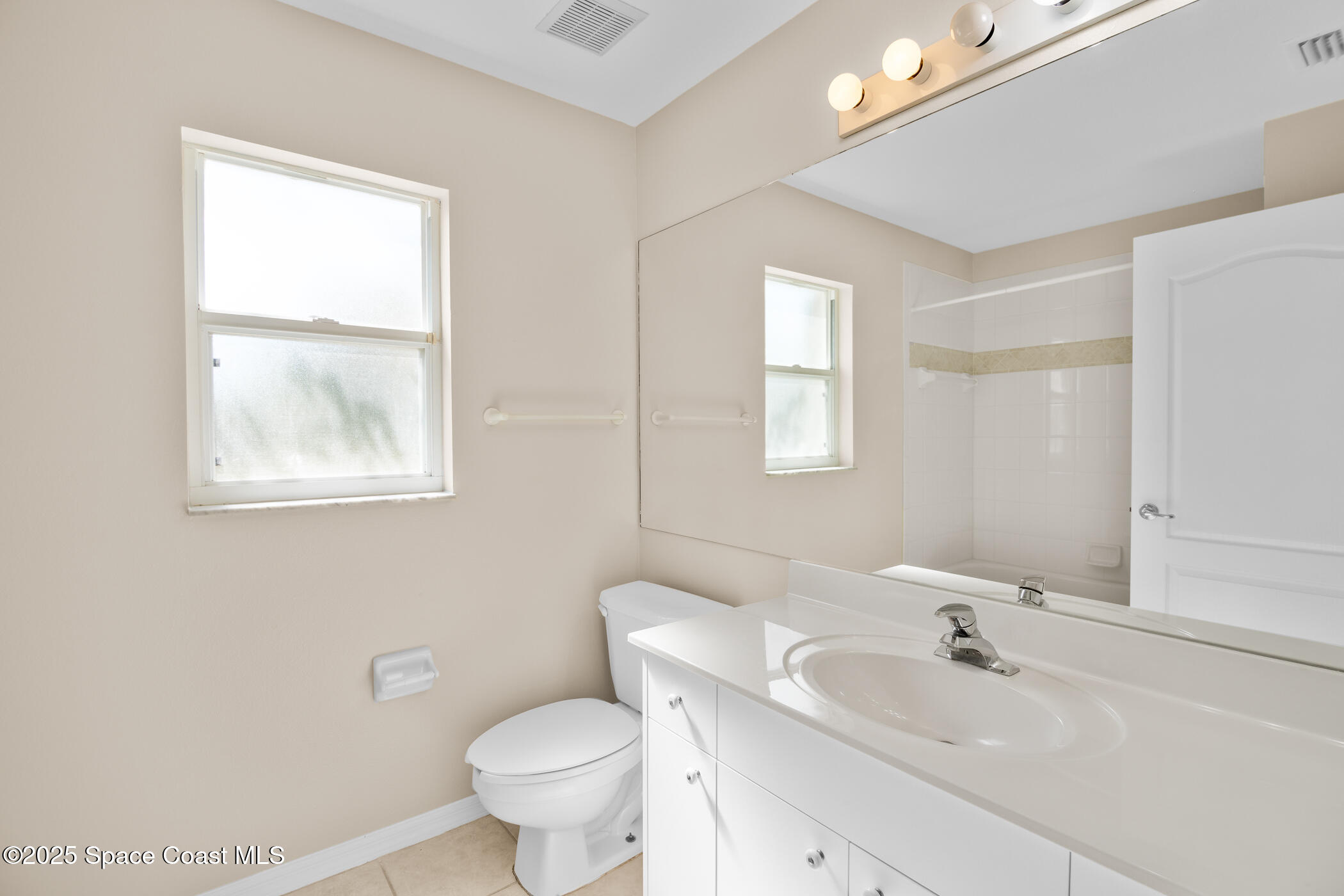 1703 Keys Gate Drive Melbourne, FL 32940 - Photo 32 of 44 a bathroom with a toilet sink and mirror