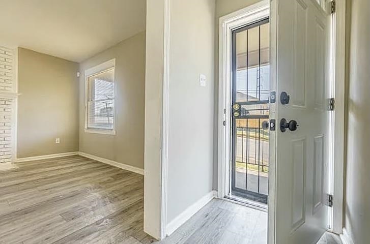 96 Modder Avenue Memphis, TN 38109 - Photo 2 of 12 an empty room that has a window and wooden floor