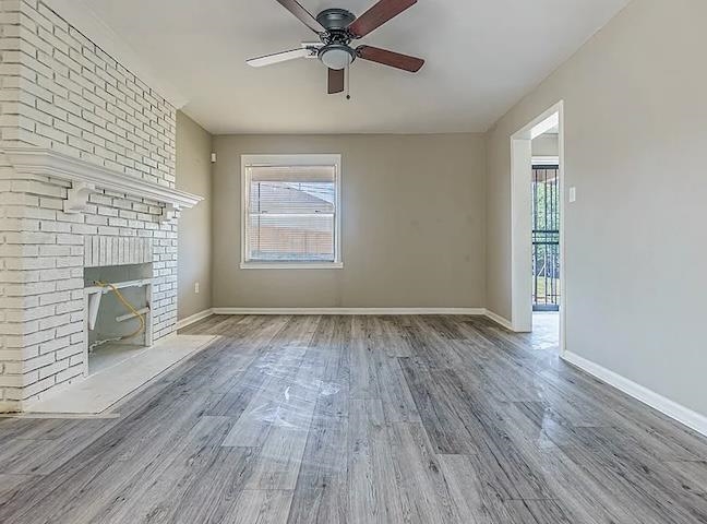 96 Modder Avenue Memphis, TN 38109 - Photo 4 of 12 an empty room with windows fireplace and wooden floor