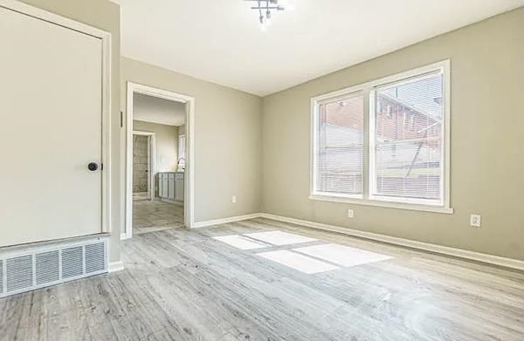 96 Modder Avenue Memphis, TN 38109 - Photo 5 of 12 a view of an empty room with wooden floor and a window