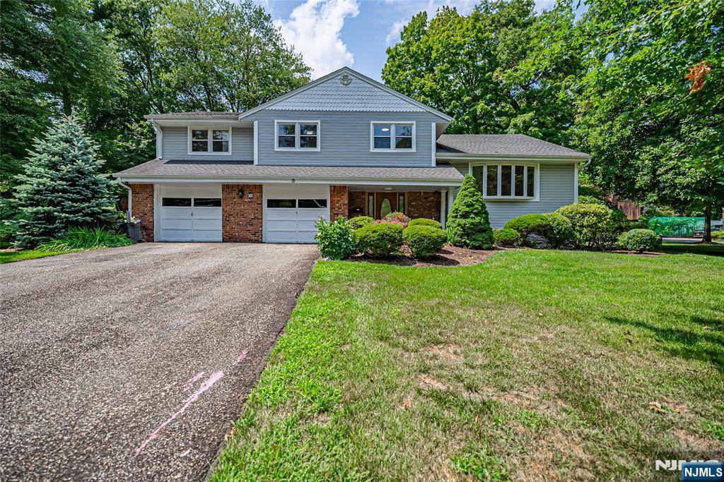 71 Columbus Road Demarest, NJ 07627 - Photo 1 of 50 a front view of a house with a yard and garage