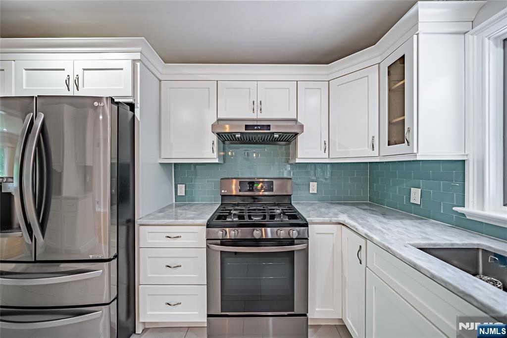 71 Columbus Road Demarest, NJ 07627 - Photo 11 of 50 a kitchen with granite countertop a stove and a refrigerator