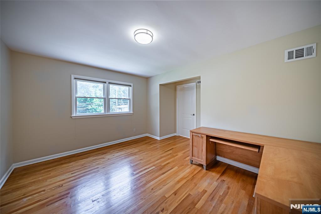 71 Columbus Road Demarest, NJ 07627 - Photo 22 of 50 a view of an empty room with wooden floor and a window
