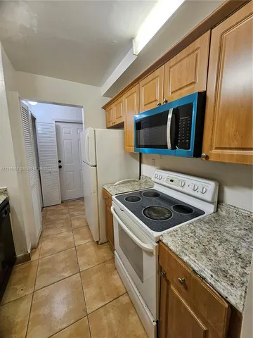a kitchen with a stove a refrigerator and a microwave