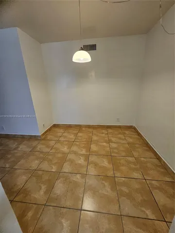 a view of a room with wooden floor and a window