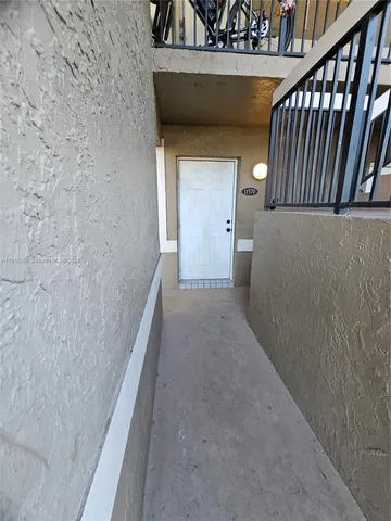 a view of a hallway with wooden floor and stairs
