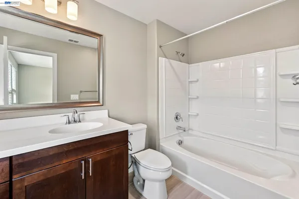 a bathroom with a sink toilet vanity and shower