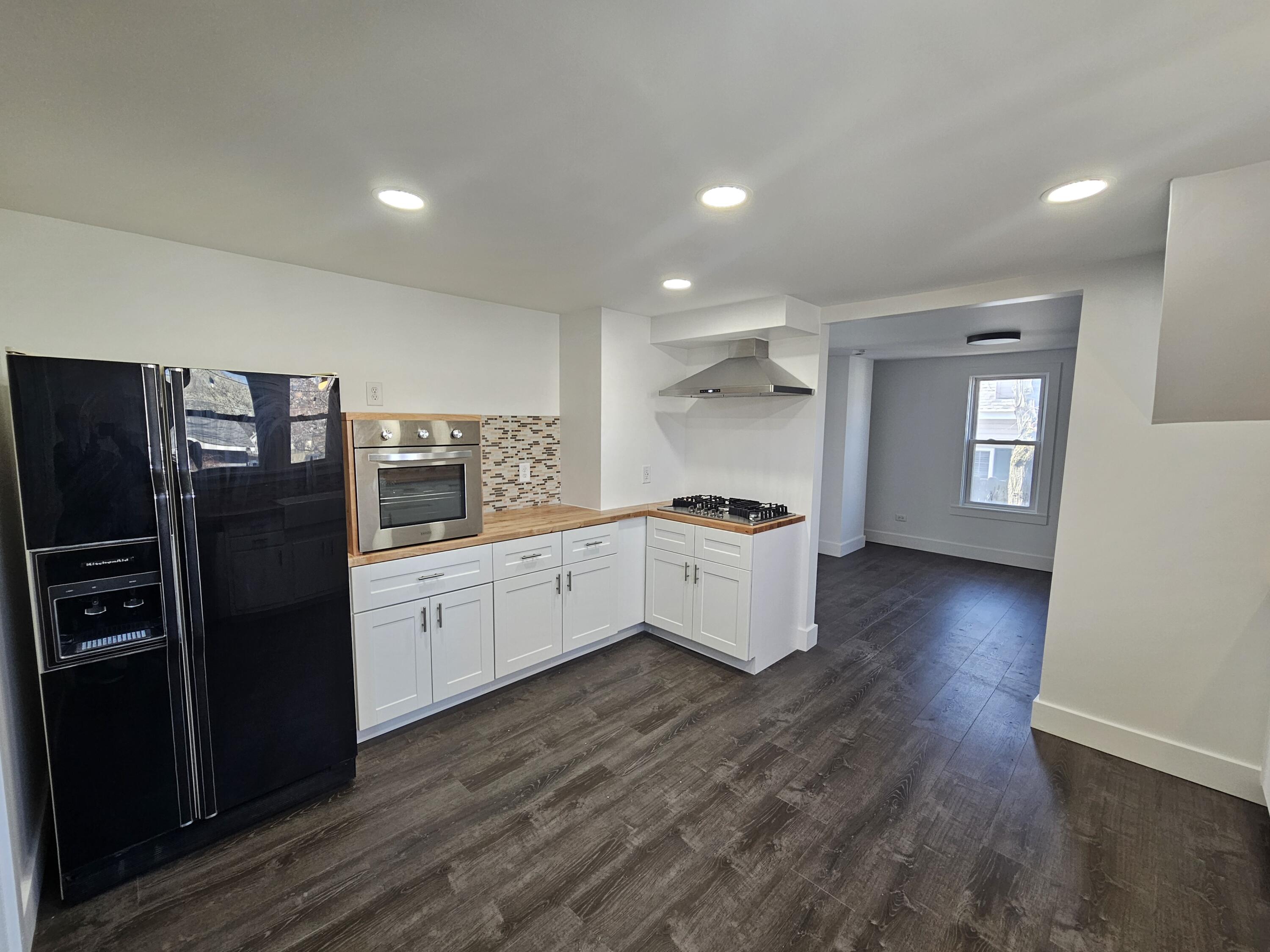 218 Fogarty Street Michigan City, IN 46360 - Photo 5 of 13 a kitchen with granite countertop a refrigerator and a stove top oven