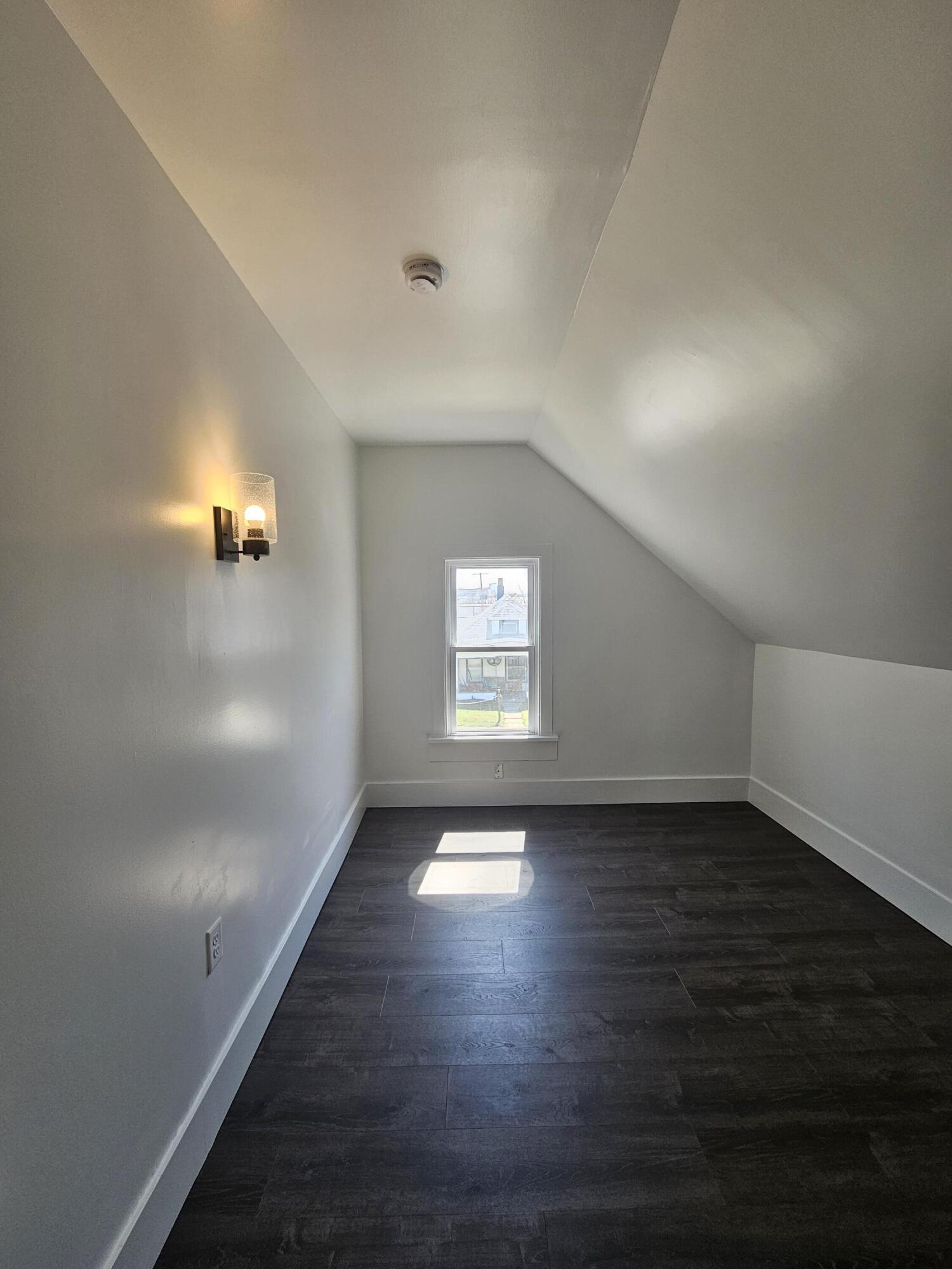 218 Fogarty Street Michigan City, IN 46360 - Photo 9 of 13 an empty room with wooden floor and windows
