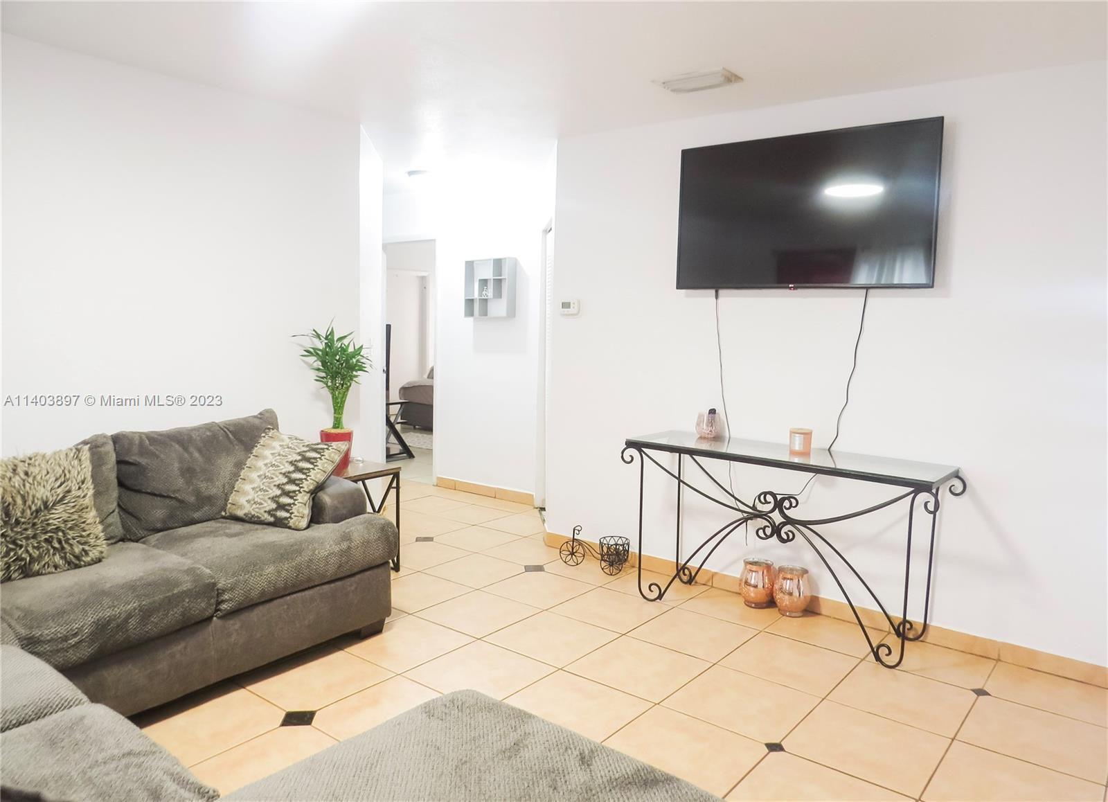 14225 Southwest 296th Street Homestead, FL 33033 - Photo 18 of 37 a living room with a couch and a flat screen tv