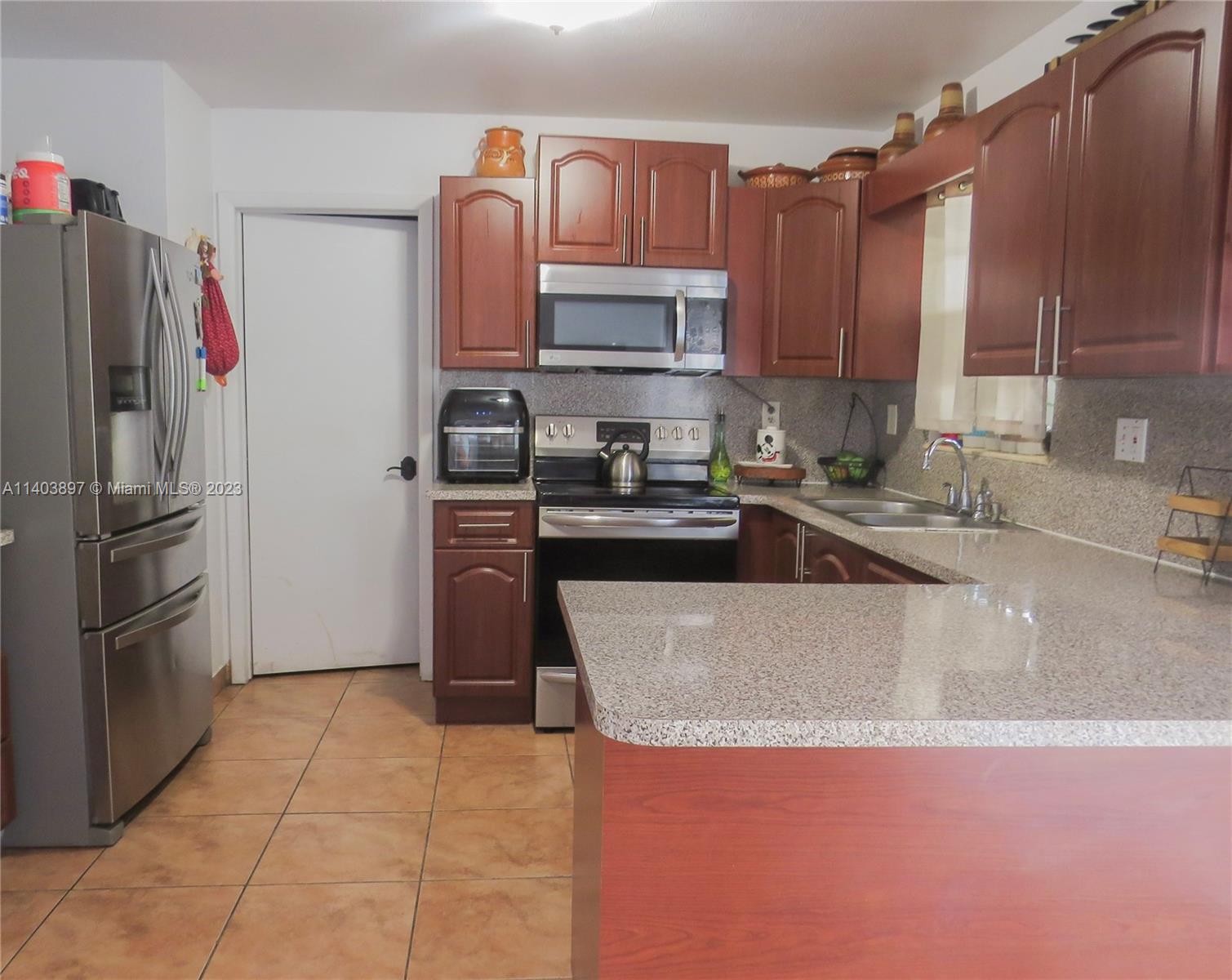 14225 Southwest 296th Street Homestead, FL 33033 - Photo 25 of 37 a kitchen with granite countertop a refrigerator and a sink