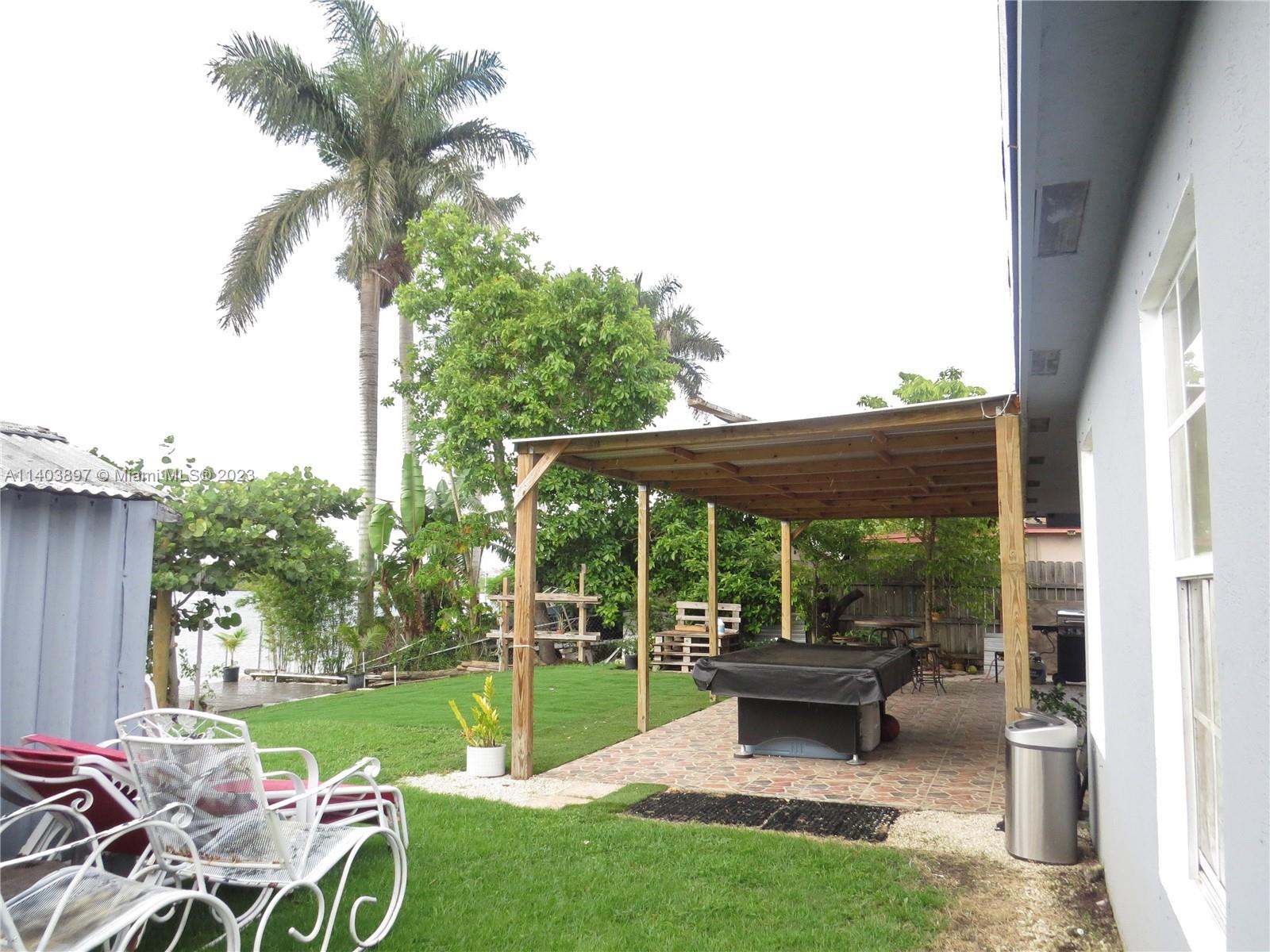 14225 Southwest 296th Street Homestead, FL 33033 - Photo 28 of 37 a backyard of a house with table and chairs