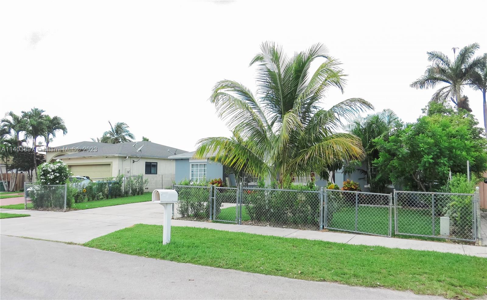 14225 Southwest 296th Street Homestead, FL 33033 - Photo 3 of 37 a front view of a house with a yard and potted plants
