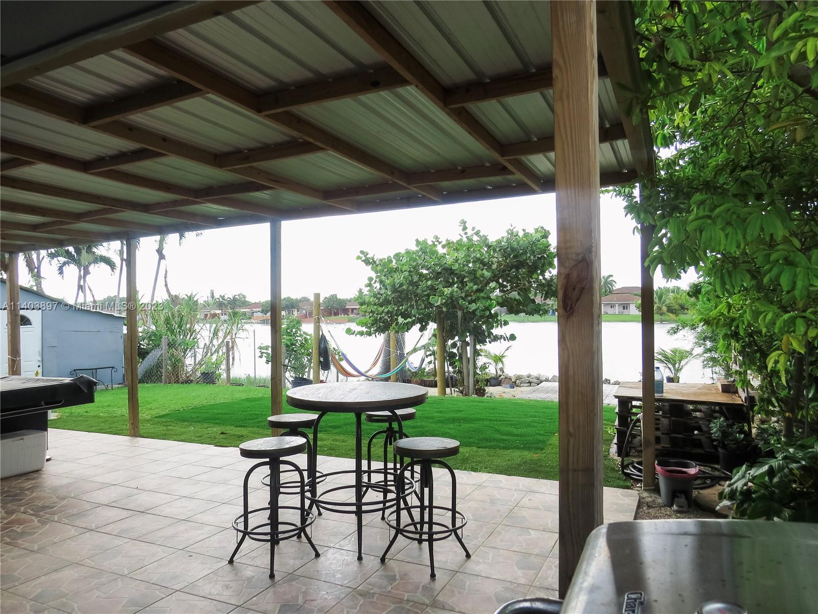 14225 Southwest 296th Street Homestead, FL 33033 - Photo 31 of 37 a view of a porch with furniture and a yard