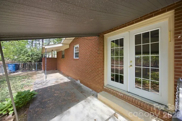 a view of a house with a yard and potted plants