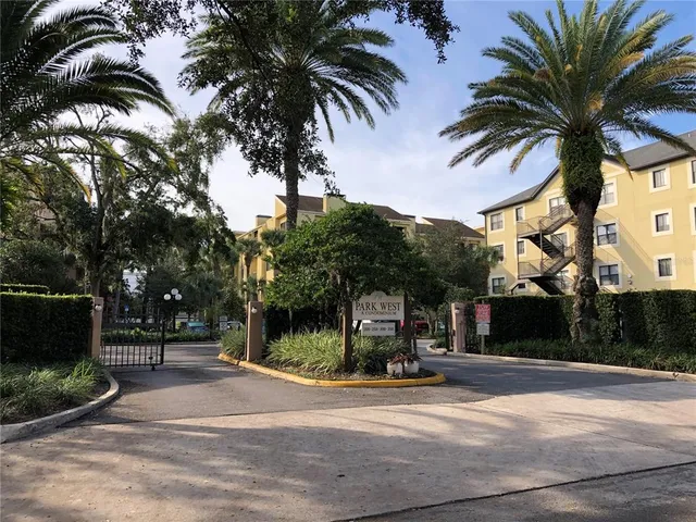 a view of a house with a yard and palm trees