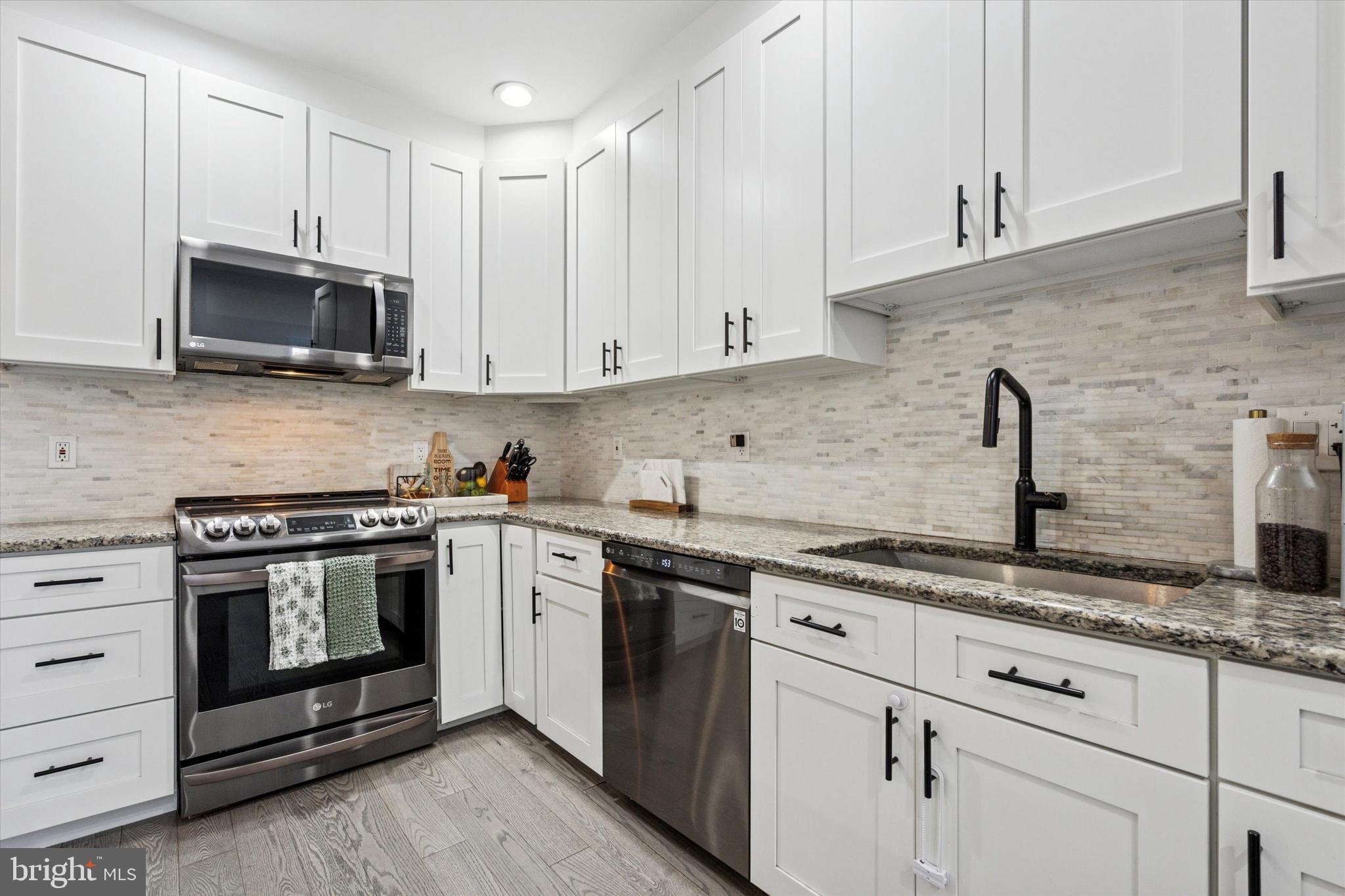 2694 Bridge Street Philadelphia, PA 19137 - Photo 10 of 41 a kitchen with stainless steel appliances granite countertop grey cabinets a stove a sink and dishwasher