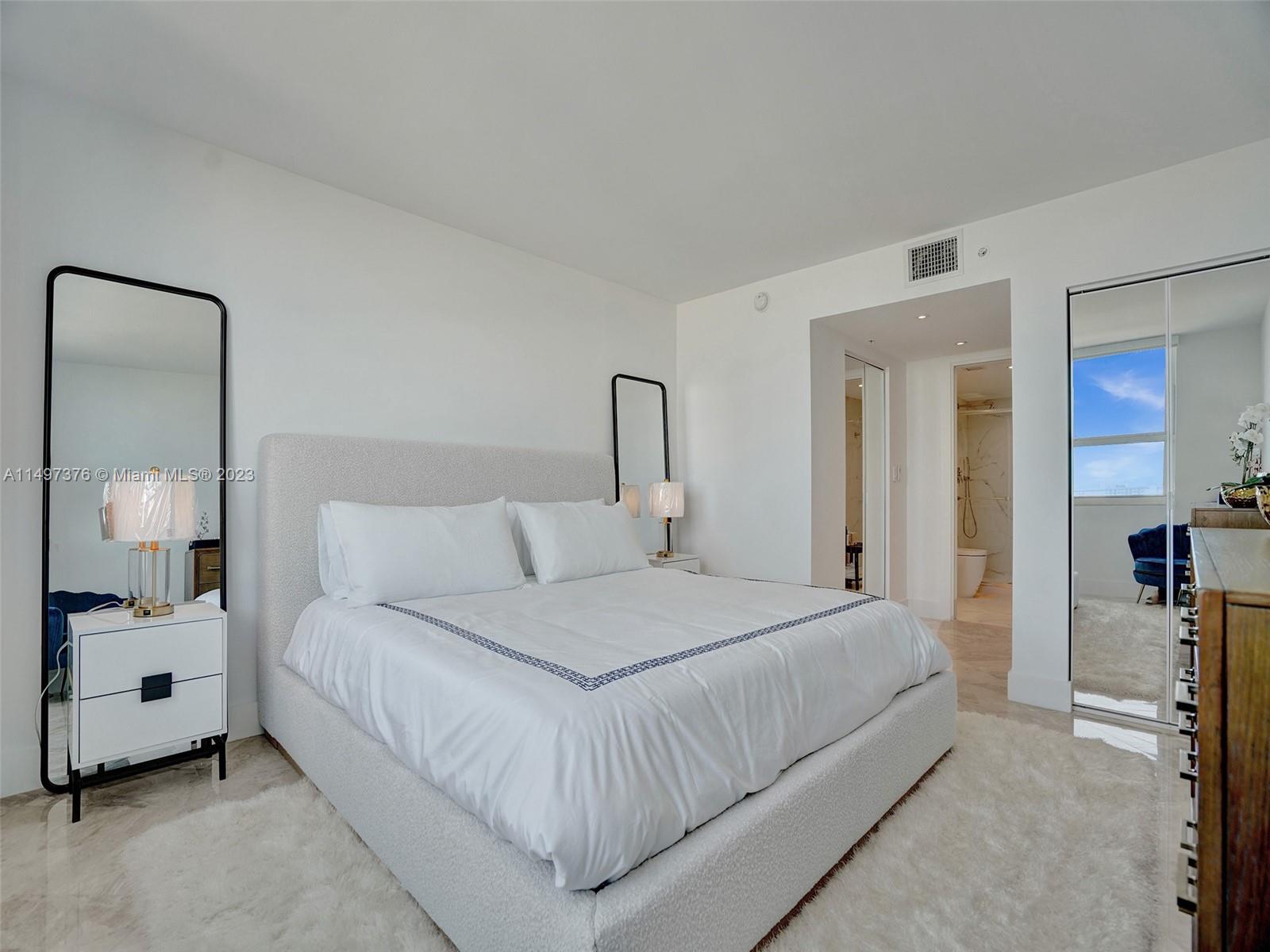 90 Alton Road, Unit 1109 Miami Beach, FL 33139 - Photo 12 of 23 a bedroom with a bed and a lamp