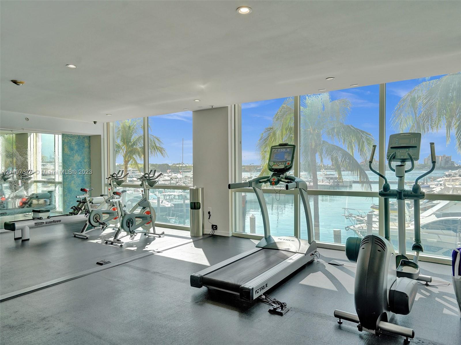 90 Alton Road, Unit 1109 Miami Beach, FL 33139 - Photo 18 of 23 a room with gym equipment and large mirror