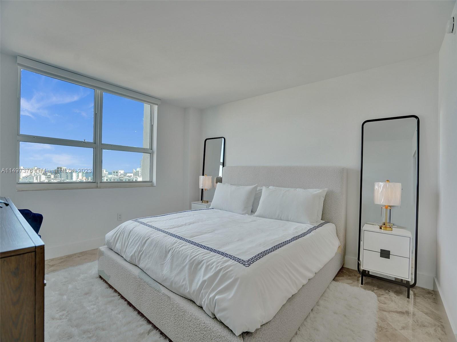 90 Alton Road, Unit 1109 Miami Beach, FL 33139 - Photo 3 of 23 a bedroom with a large bed and a window
